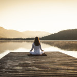 woman meditating on dock